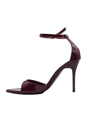 Sandalo lucido rosso scuro con tacco alto, sottile cinturino alla caviglia, punta aperta e tacco a spillo, mostrato di lato su sfondo bianco.