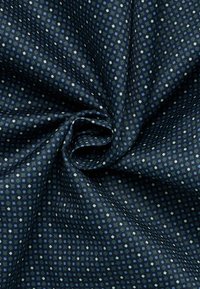 Tessuto blu navy con un motivo geometrico esagonale in blu chiaro e bianco. La texture appare liscia e finemente tessuta.