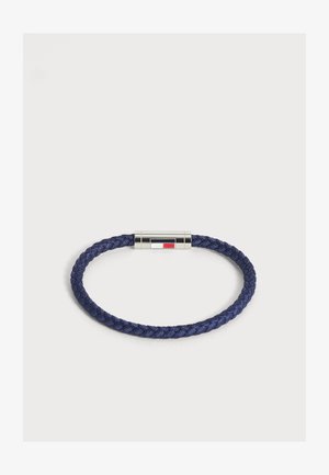 Braccialetto intrecciato blu navy con chiusura magnetica in argento con un piccolo motivo rettangolare rosso, bianco e nero.