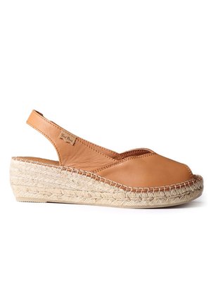 Sandale compensée en cuir couleur fauve, bout fermé, avec bride arrière, semelle plateforme en jute tressé et détails cousus sur fond blanc.
