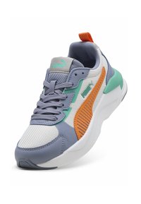 Baskets Puma avec tige en mesh blanc, lavande et sarcelle, avec des accents orange et des panneaux latéraux texturés. Semelle blanche légère.