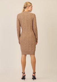 Strickkleid in Hellbraun mit einem strukturierten Rautenmuster, langen Ärmeln, geripptem Saum und figurbetonter Silhouette.