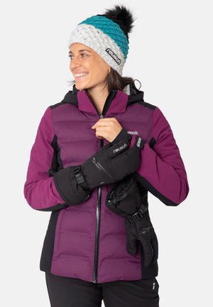 Purple insulated jacket with black accents, paired with black mittens. White and teal knitted hat with a pom-pom detail.