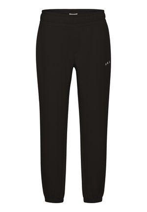 Svarta sweats med elastisk midja och gummiband vid anklarna. Har vit logotypdetalj på vänstra låret. Tillverkade av ett mjukt, flexibelt material.