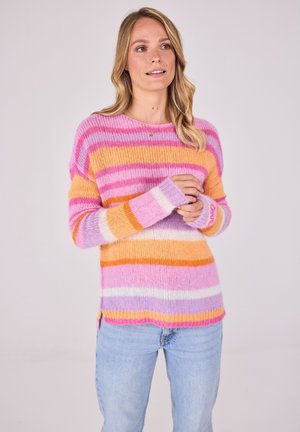 Rosa und orange gestreifter Pullover mit langen Ärmeln, locker sitzend und mit gerippten Bündchen, kombiniert mit hellblauen Jeans.