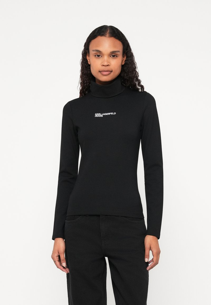 Crna turtleneck majica dugih rukava, izrađena od glatkog materijala. Sadrži Karl Lagerfeld Jeans logo u bijeloj boji na prednjoj strani.