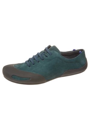 Turquoise suède sneaker met zwarte rubberen zool en neus, blauwe veters, laagprofiel ontwerp, getoond op een witte achtergrond.