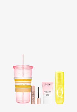 Różowy kubek Lancôme ze słomką, tubka tuszu do rzęs ze szczoteczką, różowa tubka kremu-żelu Hydra Zen i żółta butelka mgiełki do ciała Ô de Lune juice.