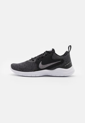 Chaussure de course Nike noire et grise avec semelle blanche, design à lacets, languette de maintien au talon et logo Nike swoosh sur le côté et la languette.