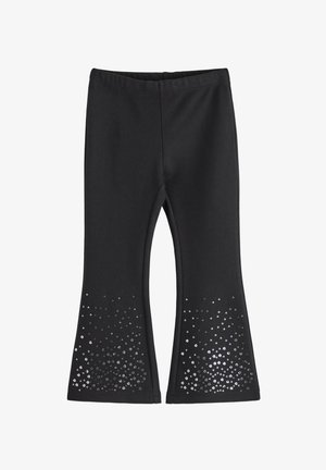 Crne flared tajice od rastezljivog materijala s sjajnim dizajnom od sequina na donjem rubu, s postupnim uzorkom točkica.