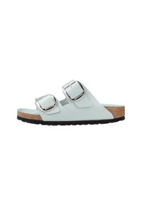 Sandali slide azzurro chiaro con due fibbie argentate regolabili, plantare in sughero e suola in gomma nera. Finitura liscia e design minimalista.