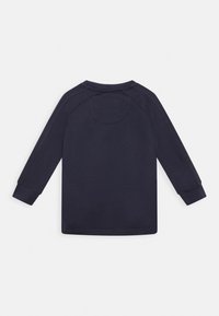 Marineblaue Langarmbluse mit gerippten Bündchen und Nahtdetails entlang der Ärmel und des oberen Rückens.