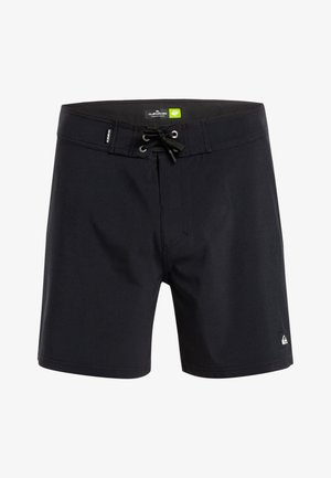 Sorte badebukser lavet af fleksibelt stof med snøre lukning, fire øjer og en lille logo-patch på den nederste venstre kant.