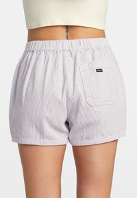 Lila Cordshorts mit elastischem Bund, ausgestattet mit einer Gesäßtasche mit einem schwarzen Logo-Patch. Strukturierte, lässige Passform, mittelhoher Schnitt.
