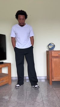 Black, wide-leg sweatpants, white t-shirt, and black sneakers. Smooth fabric, casual fit, and relaxed style against a neutral background.