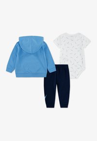 Μπλε φούτερ με κουκούλα, λευκό κοντομάνικο φορμάκι με μπλε σχέδια και σκούρο μπλε παντελόνι φόρμας με ανοιχτό μπλε λεπτομέρειες. Υλικό από βαμβακερό μείγμα.