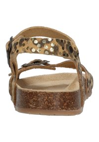 Braune Sandalen mit Leopardenmuster, die eine flache Sohle, verstellbare Riemen und metallische Akzente aufweisen. Hergestellt aus weichem, lederähnlichem Material.