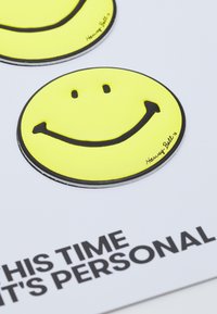 Autocolantes de rostos sorridentes amarelos com contornos pretos, exibindo olhos e uma boca curva, sobre fundo branco com texto preto.