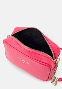 Różowa torba na ramię z sztucznej skóry z zamkiem błyskawicznym. Posiada złote okucia oraz teksturowaną wyściółkę wewnętrzną z logo marki.