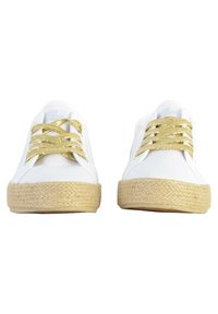 Sneakers in tela bianca con lacci dorati glitterati, punta rotonda e suola naturale avvolta in juta, caratterizzati da una texture liscia e un design minimalista.