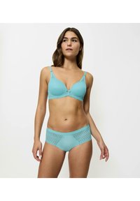 Soutien-gorge turquoise à armatures avec tissu texturé et accents en dentelle, accompagné d'une culotte hipster assortie avec une bordure à motifs.