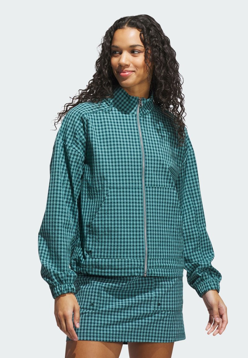 Grøn og sort ternet zip-up jakke med høj krave, elastiske manchetter og frontlommer; kombineret med en matchende mini-skirt.