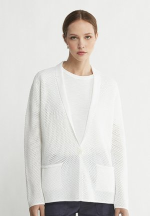 Weiße Mesh-Cardigan mit strukturiertem Muster, langen Ärmeln, Reverskragen und einem einzelnen Knopfverschluss. Verfügt über zwei Vordertaschen.