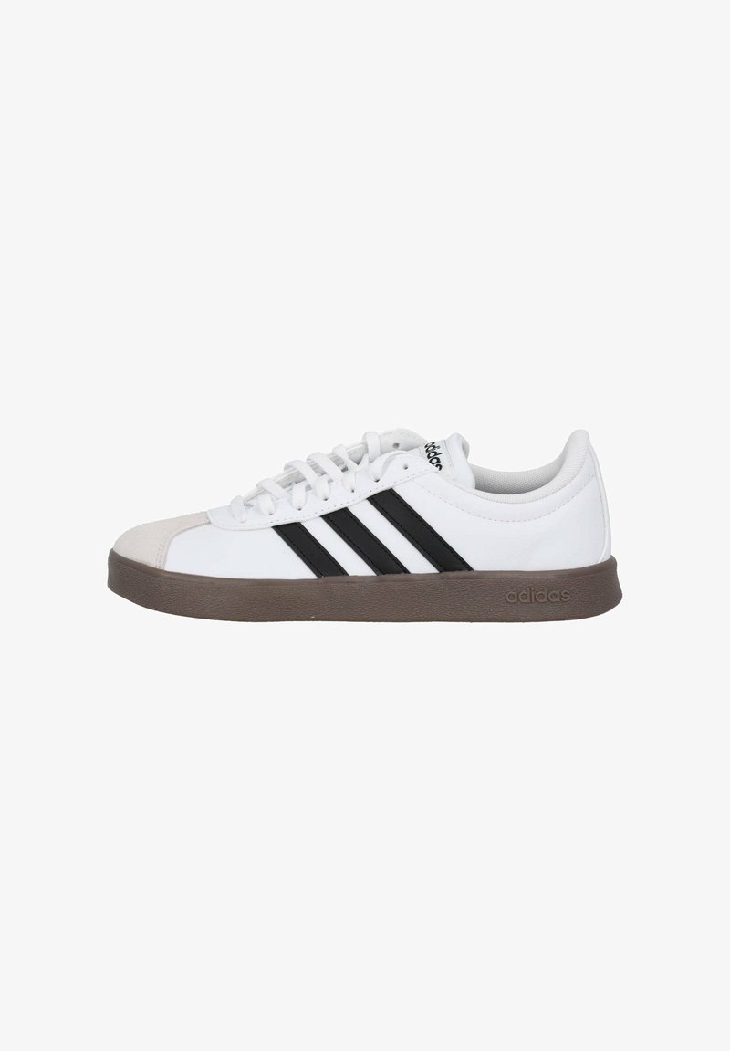 Baskets blanches avec des rayures noires, dotées d'un embout en velours et d'une semelle en caoutchouc marron. Lacets et col rembourré pour le confort.