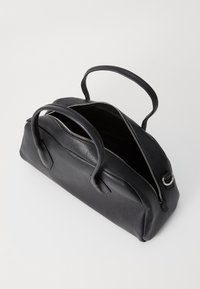 Bolsa de couro preto com fecho de zíper e duas alças, apresentando uma superfície texturizada e um topo aberto que revela um interior espaçoso.