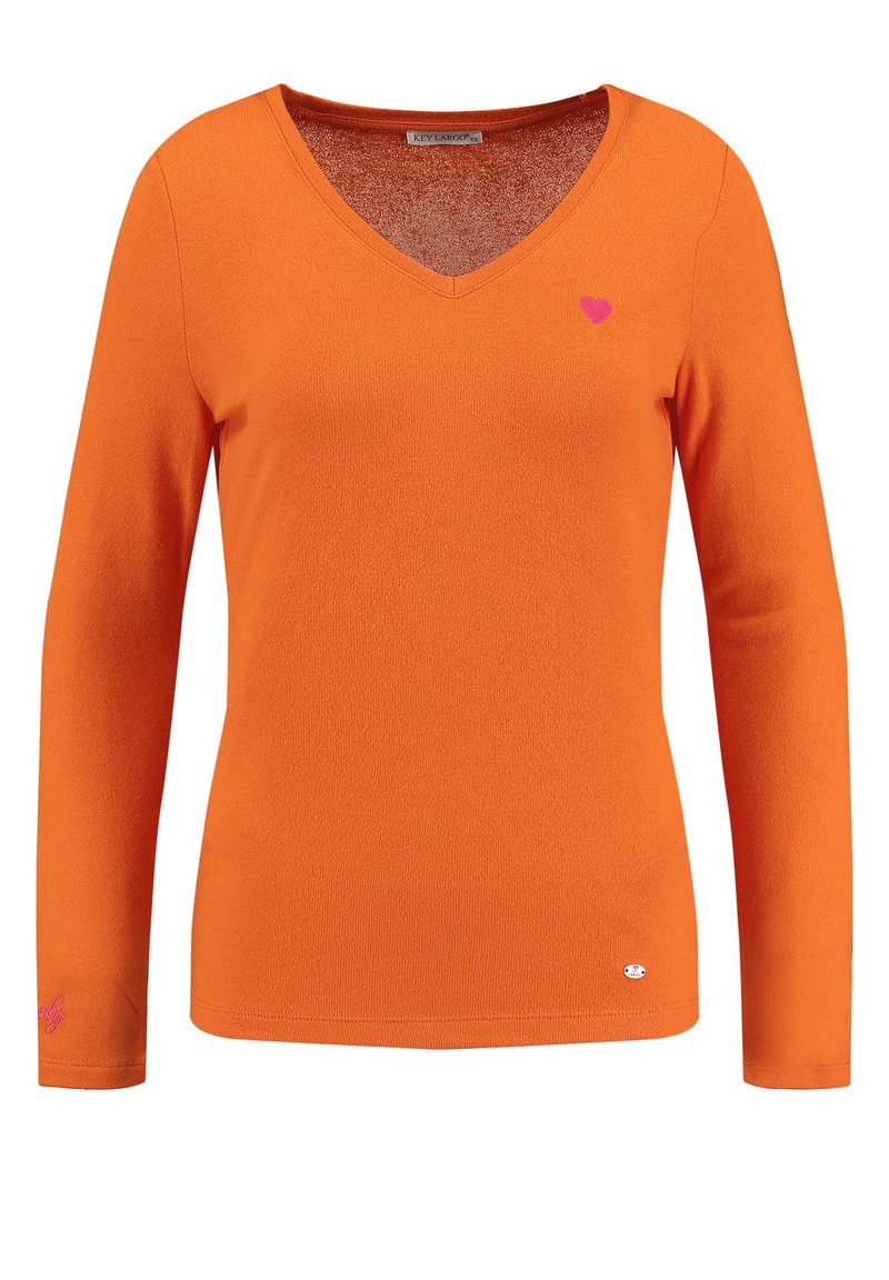 Oranges Langarm-V-Ausschnitt-Shirt aus strukturiertem Stoff. Mit einem kleinen pinken Herz auf der Brust und einem Logo-Detail am Ärmel.