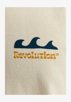 Beige katoenen stof met blauwe golfgrafieken boven de tekst "Revolutie" in oranje en gele letters. Soepele textuur, casual ontwerp.
