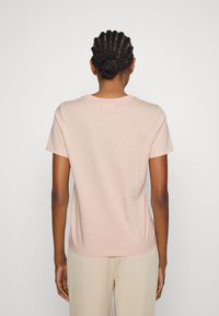 Light pink cotton t-shirt with short sleeves and a round neckline, featuring a relaxed fit and a smooth, soft texture.