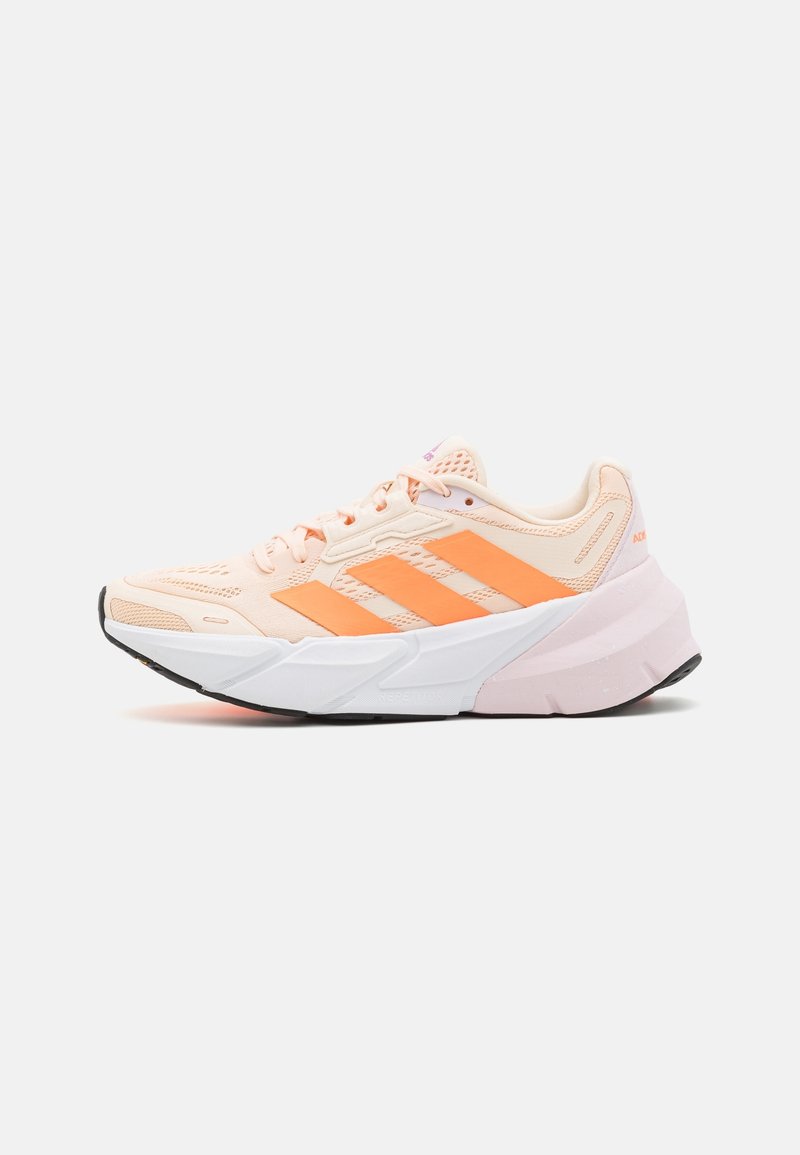 Chaussure de sport rose clair avec trois bandes orange, dessus en mesh, semelle intermédiaire blanche épaisse et semelle extérieure en caoutchouc noir. Détail notable d'amorti.