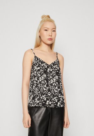Camisola a righe bianco e nero con spalline sottili, scollatura a V e bottoni decorativi, abbinata a pantaloni in pelle nera a vita alta.