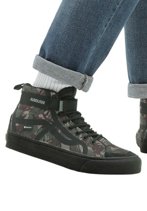 Korkeat sneakerit, joissa on maastokuvio ja mustat yksityiskohdat. Kumipohja, teksturoitu kangas ja nauhakiristyssuunnittelu. Varustettu merkkipatchilla.