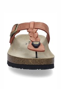 Tan suede sandaali, jossa on vuorattu nauha, metallinen solki ja korkkipohja; ominaisuuksina musta kumipohja ja keskellä pyöreä korostus.