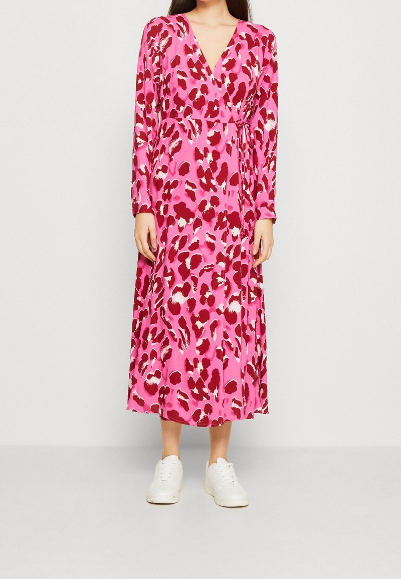 Robe portefeuille à manches longues rose avec un imprimé léopard rouge et blanc audacieux, dotée d'une ceinture à nouer à la taille et d'un ourlet fluide mi-mollet.