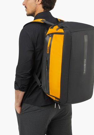 Rucksack mit einem strukturierten Design, das in Schwarz und Orange gehalten ist, aus Stoffmaterial besteht, mit Reißverschlussverschlüssen und einer Seitentasche.