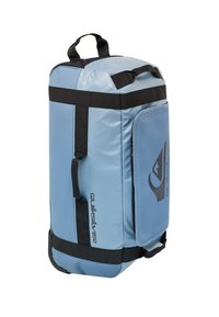 Sininen vedenpitävä urheilukassi mustilla hihnoilla ja logolla. Ominaisuuksia ovat pyöristetty yläosa, sivu vetoketjutasku ja vahvistettu pohja kestävyydelle.