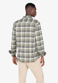 Camisa de cuadros de manga larga para hombre en verde, crema y azul marino. Cuenta con un collar abotonado, puños elásticos y un corte relajado.