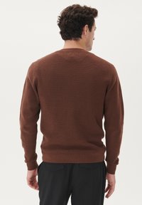Brown knitted sweater with a textured pattern, ribbed cuffs, and hem. Shaped with a round neckline, designed for a relaxed fit.