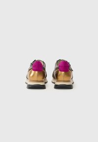 Sko med metallisk gull- og rosa semsket hæl, grå tekstiloverdel, svart gummisåle og snøring.