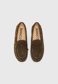 Bruine suède moccasin-stijl schoenen met veters en een strik aan de voorkant. Kenmerkt zich door metalen oogjes en een platte zool. Merkennaam: Bianco.