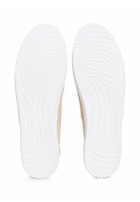 Beige kengät, joissa on vaaleat kumipohjat ja aaltoilukuviot sekä brändäys; minimalistinen muotoilu sopii vapaa-aikaan.