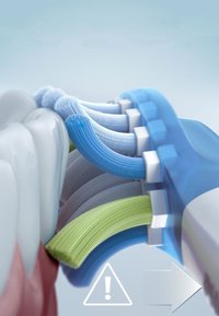Spazzolino elettrico con setole blu e verdi, manico arrotondato, design ergonomico; simbolo di avviso mostrato con una freccia. Sfondo uniforme.