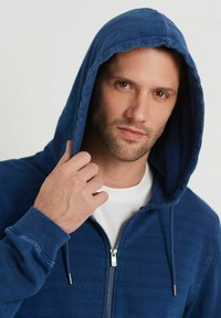 Felpa con zip blu navy in misto cotone, caratterizzata da un cappuccio con cordino, polsini a coste e tessuto testurizzato con un delicato motivo a righe.