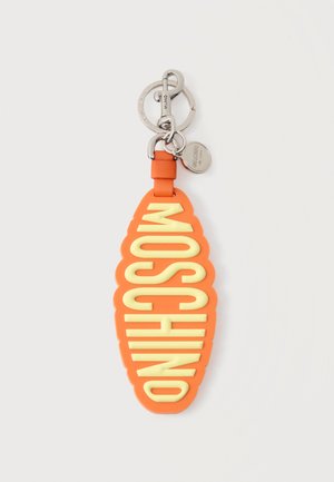 Orange gumminøglekæde med store gule "MOSCHINO"-bogstaver, sølvfarvet metalspænde og mærkat fastgjort til en hvid baggrund.