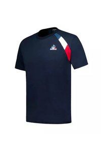T-shirt blu navy in cotone, con collo a girocollo, maniche corte e una striscia diagonale bianca, rossa e blu sulla spalla.