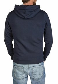 Navy blue hooded sweatshirt with a textured finish, ribbed cuffs, and hem, paired with light wash jeans featuring back pockets.