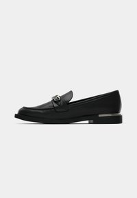 Musta nahast loaferid ümarate varvastega, ees rihm, hõbedaste detailidega ning madala tekstuuriga tallaga. Elegantselt lihtne disain minimaalse kaunistusega.